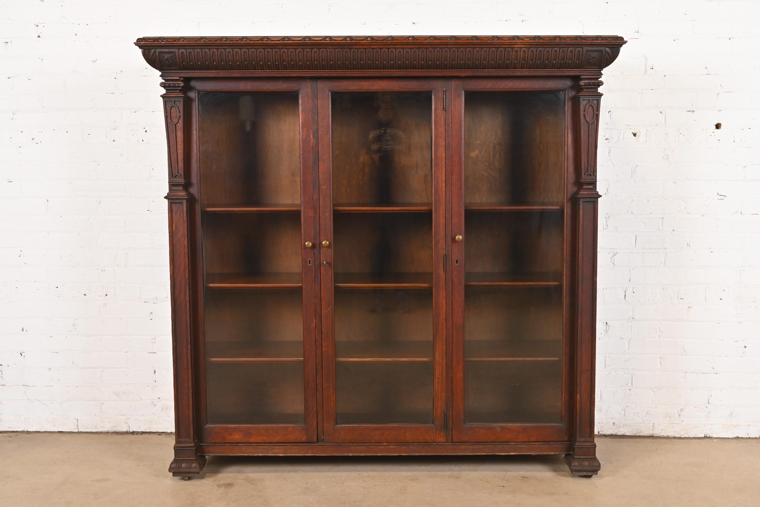 R. J. Horner Style American Empire Carved Oak Glass Front Triple Bookcase Cabinet, Circa 1890
