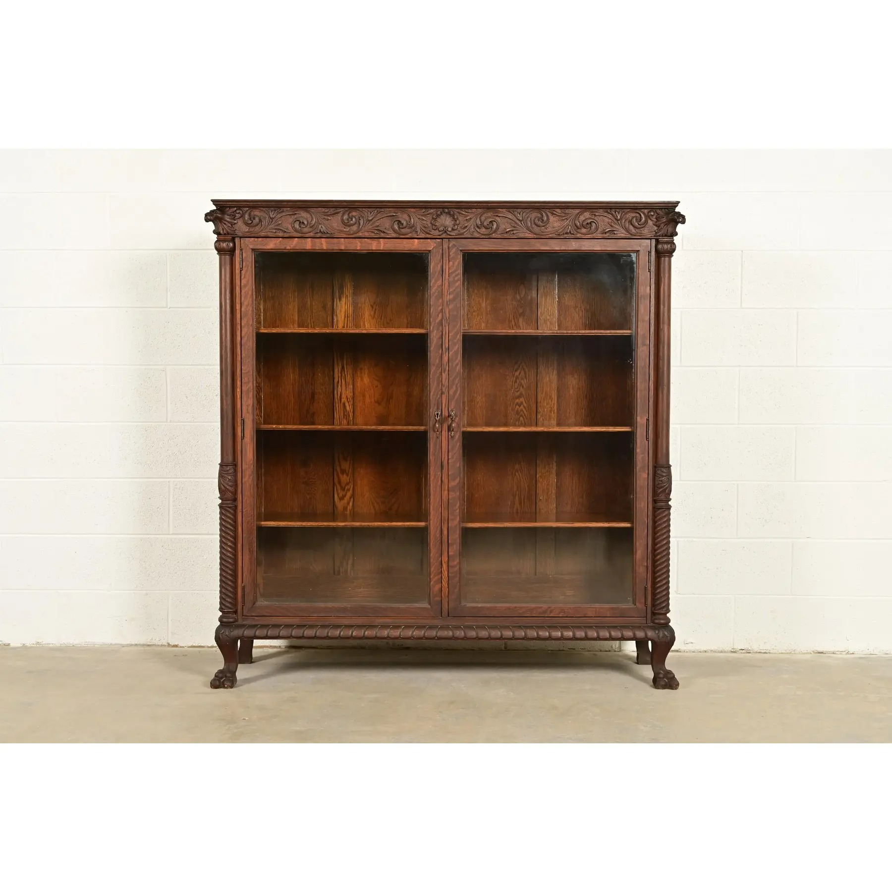 R. J. Horner Style Victorian Oak Double Bookcase With Carved Lion Heads and Paw Feet, Circa 1890s