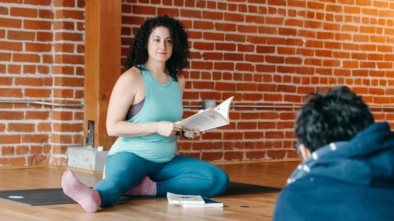 yoga teacher reading from manual in advanced yoga teacher training in Los Angeles