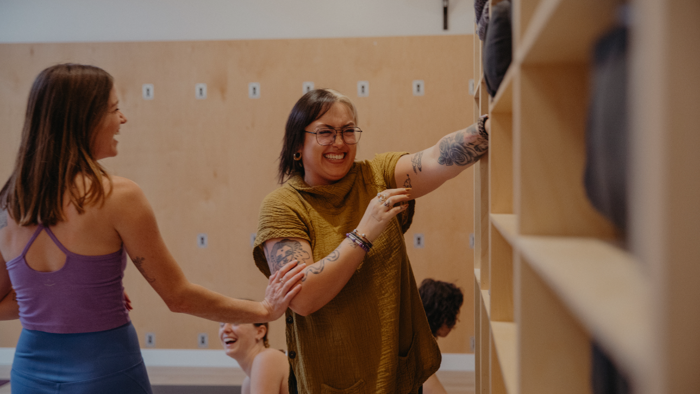image of LA-East-Hollywood-Yoga-student-putting-away-props-and-chatting-with-another-student