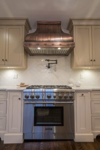 copper hood on six-burner gas oven range