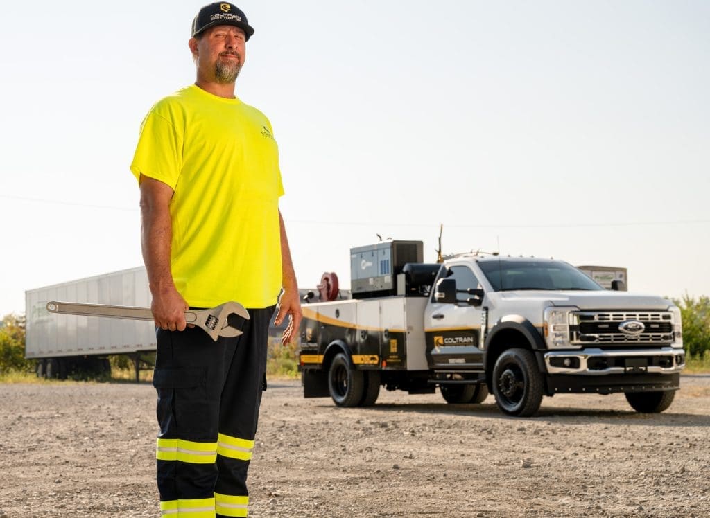 Justin Mertz, a Coltrain Onsite Fleet Care mobile technician, stands with an adjustable wrench in front of his Ford F-550 mobile service truck.