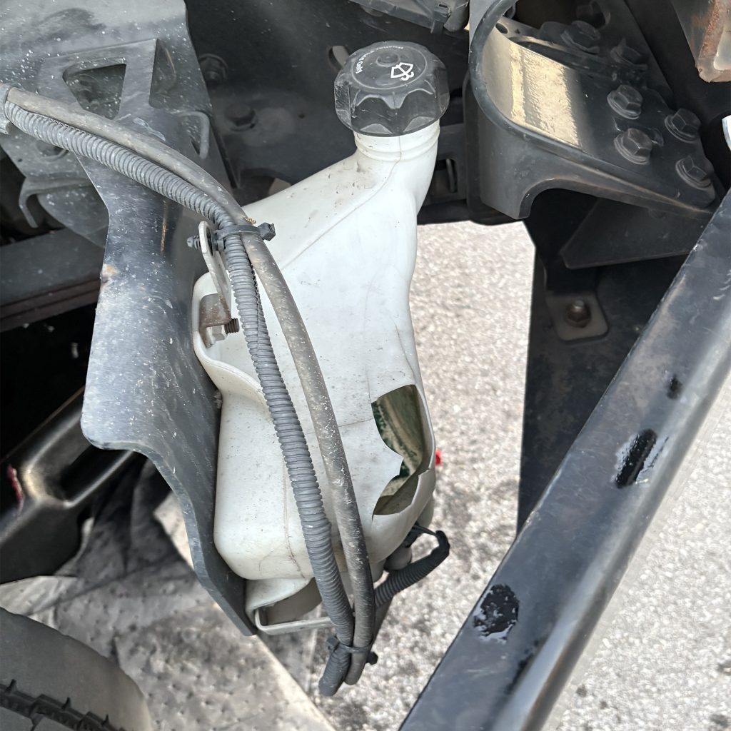 Cracked windshield washer fluid reservoir found during Coltrain Onsite Fleet Care SHIELD™ preventive maintenance inspection.