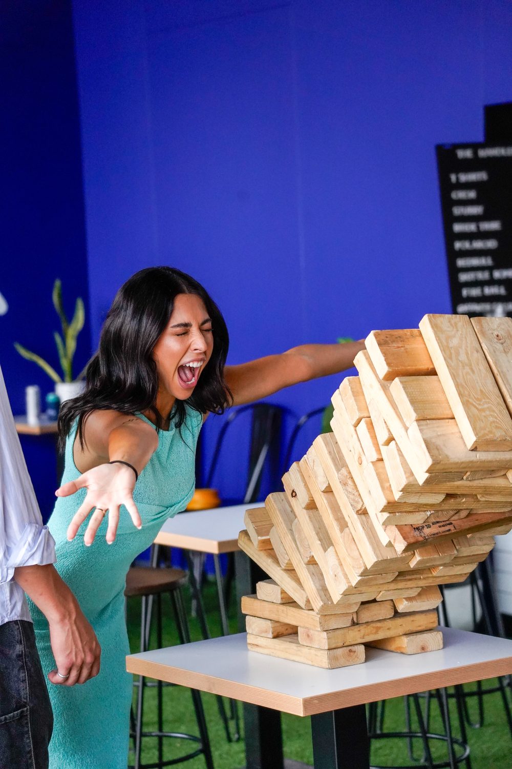 A guest reacting as the giant Jenga tower collapses at HomeBase