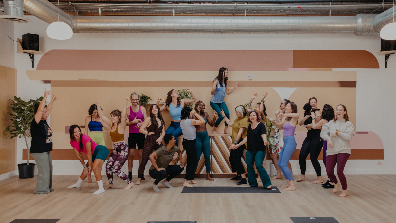 the One Down Dog yoga team dancing together in the studio
